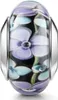 Schwarzer Glas Bead mit lilanem und blauen Blumenmuster, in silberner Hülse, frontal fotografiert auf weißem Hintergrund. Produktbild-Vorschau