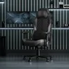 A gaming chair in a modern, dimly lit room with multiple monitors. Anteprima dell’immagine prodotto