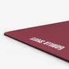 A close-up, angled view of a dark red yoga mat with white text on it, set against a white background. Náhľad obrázku produktu