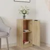 A small wooden cabinet with its door open, placed in a room next to a chair. A vase of white flowers sits on top of the cabinet. Náhľad obrázku produktu