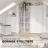 A white filing cabinet with drawers and a dark grey top is shown in a room with slanted ceilings and white furniture, including a bookshelf. Pillows and a basket of magazines are on the floor. Produktbild-Vorschau
