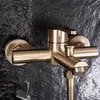 A close-up shot of a gold-colored shower faucet mounted on a dark, textured wall. Produktbild-Vorschau