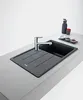 A modern kitchen sink with a faucet and a small tray of condiments on a countertop. Produktbild-Vorschau