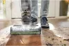 A person is using a BISSELL CrossWave Hydrosteam vacuum cleaner on a floor that appears to be a mix of wood and tile, with some dirt and debris visible. Voir les images du produit