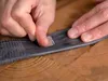 Hands repairing a bicycle inner tube with a patch kit. Produktbild-Vorschau