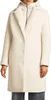 A woman wearing a cream-colored coat.