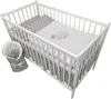 A white wooden crib filled with baby bedding. A grey and white star-patterned blanket is rolled up and tied with a bow to the left of the crib. Produktbild-Vorschau
