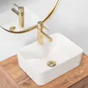 A white rectangular vessel sink with a gold faucet and drain sits on a wooden countertop. Anteprima dell’immagine prodotto