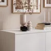 A white dresser with decorative items and books on top. Produktbild-Vorschau