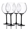 Four clear wine glasses with black stems and bases are arranged in a row against a white background. Podgląd zdjęcia produktu