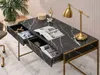 A modern desk with marble-like finish and gold legs, featuring open drawers with magazines and decorative items. Voir les images du produit
