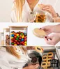 Collage of images showing glass storage jars with bamboo lids filled with various food items like pasta, candies, and coffee beans. Produktbild-Vorschau
