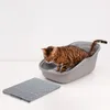 A Bengal cat is stepping out of a gray litter box onto a gray litter mat. Produktbild-Vorschau
