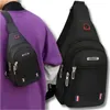 A person wearing a purple shirt and a black sling bag. Voir les images du produit