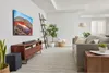 A modern living room with a TV, soundbar, subwoofer, sofa, and decorative items. Produktbild-Vorschau