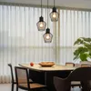 A dining table with chairs and pendant lights hanging above. Náhľad obrázku produktu