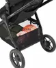 Close-up view of the storage basket of a stroller, containing a basketball and a stuffed toy. Produktbild-Vorschau