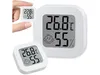 A hand is holding a small digital thermometer and hygrometer, with a larger one in the background. Podgląd zdjęcia produktu