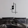 A modern abstract clock mounted on a wall above a bed with pillows and blankets. Anteprima dell’immagine prodotto