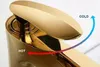 Close-up of a gold faucet with arrows indicating hot and cold water flow. Produktbild-Vorschau