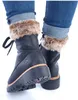 A close-up shot of a person wearing black boots with fur trim and cuffed jeans. Anteprima dell’immagine prodotto