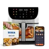 A Tesla AirCook Q70 XXL WiFi Pro multifunktionale digitale Heißluftfritteuse is shown with a recipe book and a smartphone displaying the app. Náhľad obrázku produktu