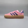 A side view of a pink Adidas Gazelle Bold sneaker with navy stripes and a brown platform sole, set against a plain gray background. Náhled obrázku produktu