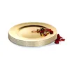 A stack of gold charger plates with some decorative elements on top. Produktbild-Vorschau