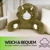 A dinosaur-shaped pillow is placed on a sofa, with text overlays at the bottom. Podgląd zdjęcia produktu