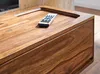A close-up shot of a wooden TV stand with a remote control on top. Produktbild-Vorschau