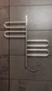 A modern, sleek electric towel warmer mounted on a textured gray tile wall. Podgląd zdjęcia produktu