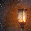 A solar garden light with a flame effect is shown in the rain. Náhled obrázku produktu