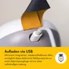 Close-up of a USB charging port on a white and gray electric breast pump, with a yellow and dark gray fabric strap visible. Podgląd zdjęcia produktu