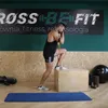 A man is performing an exercise with resistance bands and a plyometric box in a gym. Náhled obrázku produktu