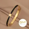 XCOAST Armreif aus Edelstahl – goldfarben mit schwarzen Produktbild-Vorschau 1