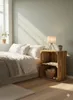 A bedroom scene with a bed and a wooden crate nightstand. Produktbild-Vorschau