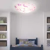 A ceiling light fixture with a pink unicorn and star pattern is shown mounted on a white ceiling above a bed in a child's room. Produktbild-Vorschau