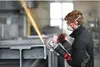 A person is using an angle grinder to cut metal in a workshop. Produktbild-Vorschau