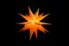 A star-shaped lantern hangs against a black background. Produktbild-Vorschau