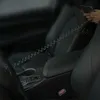 A person's hands are shown holding a smartphone connected to a coiled USB-C cable, which is plugged into a car's charging port. Anteprima dell’immagine prodotto