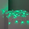 Green LED string lights draped over a white surface. Produktbild-Vorschau