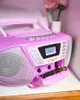 A pink boombox with the cassette deck open, showing the tape mechanism. There are decorative crocheted flowers in a vase in the background. Produktbild-Vorschau