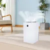A white air purifier is shown in a living room setting with a chair and a plant. Produktbild-Vorschau