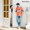 A man and a woman are interacting in a room, with the woman peeking through a doorway. Produktbild-Vorschau