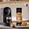 A coffee machine with a cup of espresso and a box of coffee capsules, along with some white chocolate and almonds. Náhľad obrázku produktu