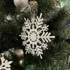 A close-up shot of a white snowflake ornament hanging on a Christmas tree. Náhled obrázku produktu