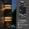 A split image showing a black outdoor wall light mounted on a brick wall on the left, and a product shot of the same light on a dark gray background on the right, with feature callouts. Produktbild-Vorschau