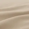 A close-up view of beige fabric with soft folds and textures. Produktbild-Vorschau
