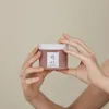 Hands holding a jar of skincare product. Produktbild-Vorschau