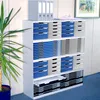 A white shelving unit filled with drawers, containing office supplies, next to a potted plant. Voir les images du produit